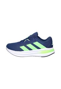 Zapatillas deportivas azul marino con detalles en verde, parte superior de malla, entresuela blanca acolchada y suela exterior de goma negra con un patrón texturizado.