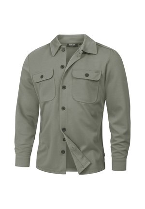 Oliivinvihreä napitettava paita, jossa on kaulus, pitkät hihat, kaksi rintataskua ja rento istuvuus. Valmistettu pehmeästä, teksturoidusta kankaasta.