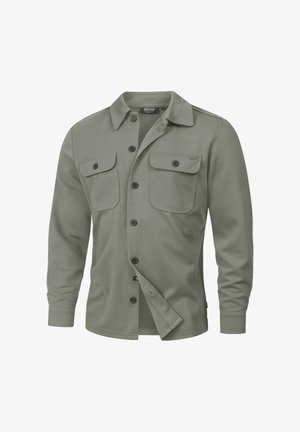 Oliivinvihreä napitettava paita, jossa on kaulus, pitkät hihat, kaksi rintataskua ja rento istuvuus. Valmistettu pehmeästä, teksturoidusta kankaasta.