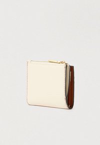 Small textured leather wallet in cream with brown interior and gold zipper on top, shown slightly folded.