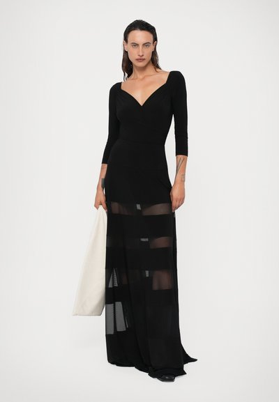 Rochie lungă neagră cu mâneci lungi, având un bust ajustat și o fustă transparentă cu dungi. Material moale cu decolteu adânc și design fluid.