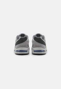 Herrarnas sportskor med en grå mesh-övre, mockadetaljer, en dämpad sula och en blåtintat hälen.