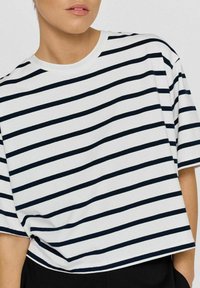 Bomulds t-shirt med hvid base og brede mørkeblå vandrette striber, rund halsudskæring, korte ærmer, løs pasform og croppet længde.