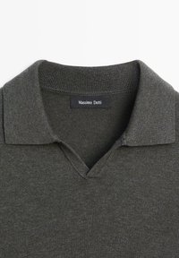Pull polo en maille gris foncé avec col côtelé et ouverture en V, arborant une étiquette noire avec la marque "Massimo Dutti" en blanc.