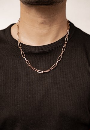 Metallkettenschnur mit länglichen, ovalen Gliedern, die abwechselnd mit polierten und strukturierten Oberflächen versehen sind, präsentiert auf einem schwarzen gerippten Hemd.