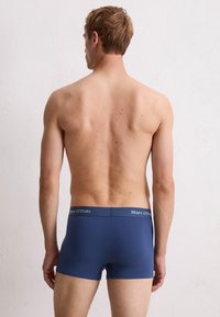 Granatowe bawełniane bokserki z miękkim paskiem w talii, na którym znajduje się logo "Marc O'Polo". Dobrze dopasowany krój i gładka struktura materiału.