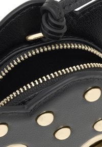 Czarna skórzana torba z dwoma zamykanymi na zamek przegrodami, ozdobiona metalowymi akcentami w kolorze złota oraz ćwiekami na zewnątrz.