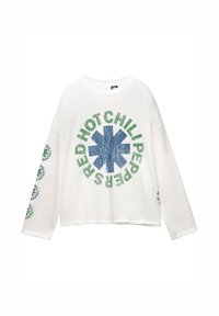 Witte langemouwen shirt met een versleten blauw asterisk en groene cirkelvormige tekst "Red Hot Chili Peppers" op de voorkant en mouwen.