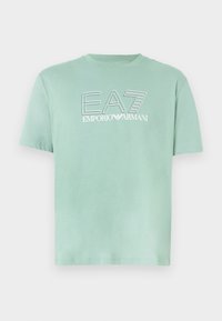 Világoszöld pamut póló kerek nyakkivágással, rövid ujjú, elől kontrasztos fehér színű "EA7 EMPORIO ARMANI" nyomott logóval.