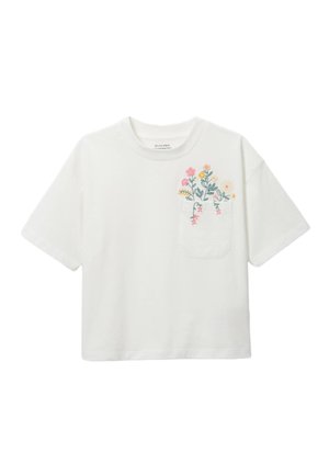 T-shirt blanc à manches courtes avec une petite poche poitrine ornée de fleurs brodées en rose, jaune et crème, avec des feuilles vertes au-dessus et autour de la poche.