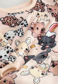 Tessuto rosa chiaro con stampe di animali cartoon vivaci, tra cui gatti, cani e coniglietti. Presenta polsini a coste e dettagli arricciati.