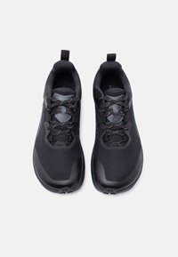 Ζευγάρι μαύρα αθλητικά παπούτσια με πλέγμα επάνω μέρος και κορδόνια με μοτίβο, από πάνω με φόντο λευκό.