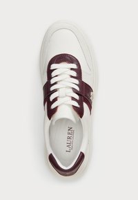 Baskets en cuir blanc avec des accents bordeaux, lacets plats, côtés texturés et un détail de logo signature sur le côté extérieur.