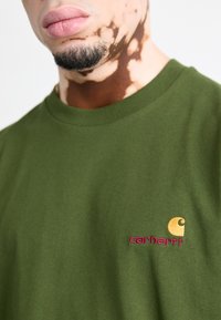 Carhartt WIP AMERICAN SCRIPT - T-Shirt basic - tarragon