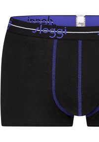 Miesten mustat boxershortsit, joissa on violetti kuminauha, jossa valkoista tekstiä, ja violetit ompeleet saumoissa. Pehmeää, joustavaa kangasta.