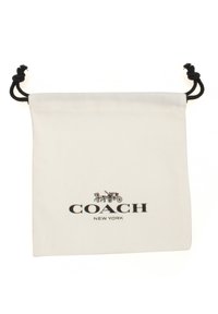Bolsita de algodón blanco con cordón y herrajes negros, que presenta un logo impreso que dice "COACH NEW YORK" encima de un diseño decorativo de un carruaje.