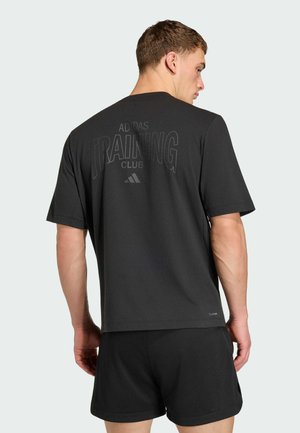 T-shirt de sport noir à manches courtes, avec un grand imprimé "ADIDAS TRAINING CLUB" au dos. Tissu doux avec une texture lisse.
