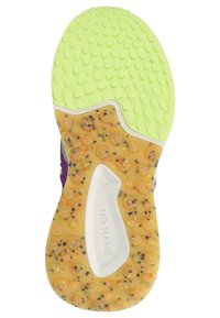 Sole of a sneaker featuring a textured bright yellow-green rubber surface with raised dots and a speckled, translucent orange base.