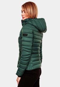 Jachetă puffer verde cu glugă, textură ribbed, închidere cu fermoar și petic cu logo pe mânecă. Dispune de o siluetă ajustată și manșete elastice.