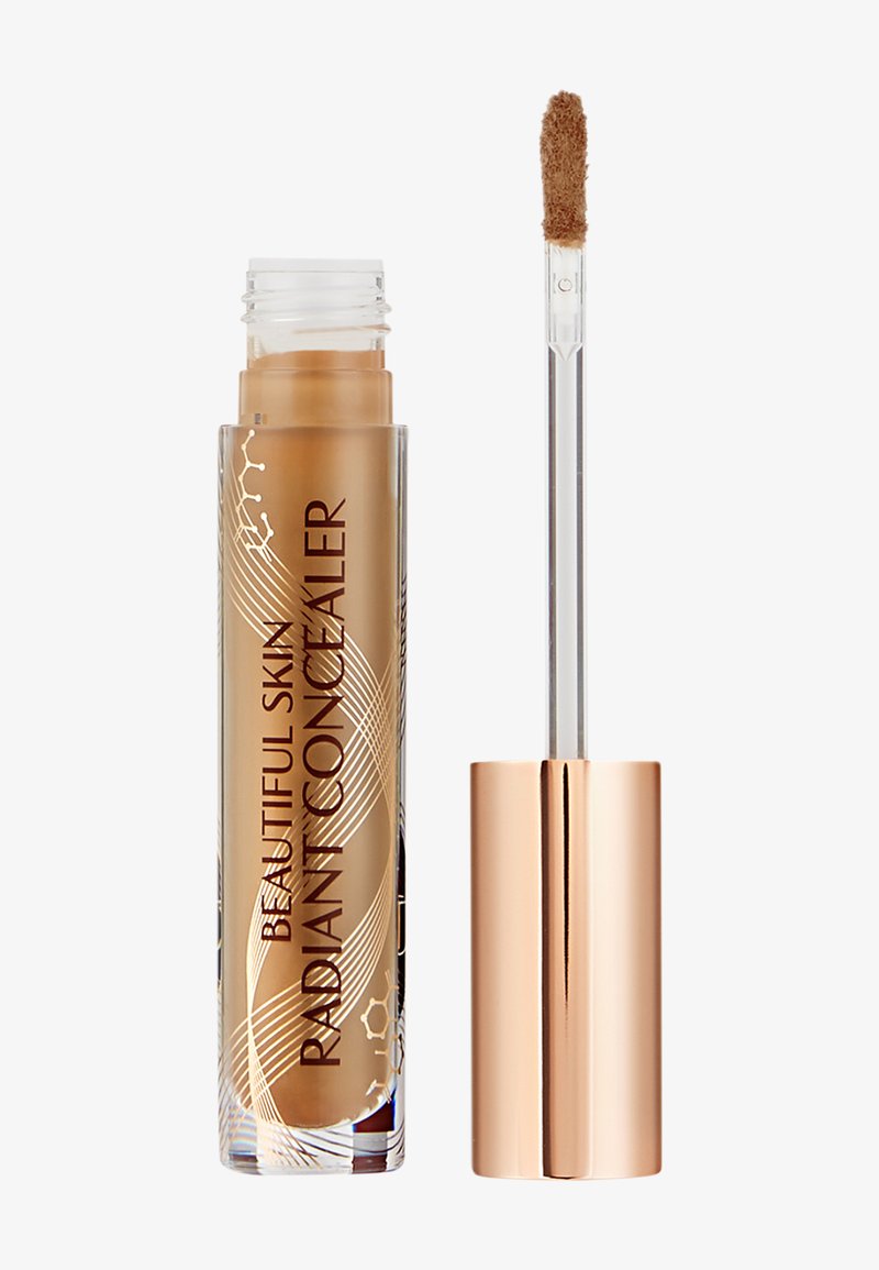 Correttore in un contenitore tubolare trasparente con accenti dorati. Presenta un morbido applicatore a wand. Il colore del prodotto è un marrone medio caldo.