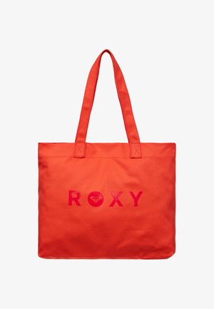 Jasnopomarańczowa torba typu tote z dwoma paskami na ramię i nazwą marki "ROXY" wydrukowaną pogrubionymi czerwonymi literami z przodu.