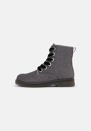 Bottine cheville gris foncé pailletée avec lacets noirs, œillets argentés, languette au talon et semelle épaisse noire avec coutures visibles.