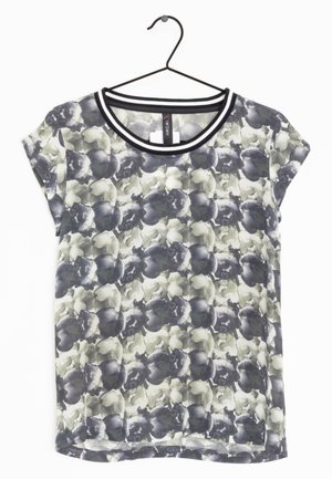 Haut pour femme à manches courtes avec motif floral noir et blanc et encolure ronde rayée noir et blanc sur un cintre.