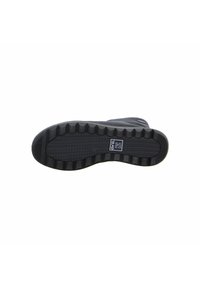 Suela de zapato negra con goma texturizada, que presenta un patrón acanalado para mayor agarre y una etiqueta de logo rectangular en el centro.