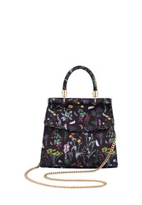 Crna cvjetna torba od tkanine s zlatnom lančanom trakicom. Ima gornju dršku, preklopnu zaštitu i šareni botanički uzorak.