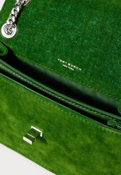Zelena zamšena torbica Tory Burch s srebrnim verižnim naramnicom in pravokotnim srebrnim sponko, delno odprta in razkriva gladko notranje obloge.