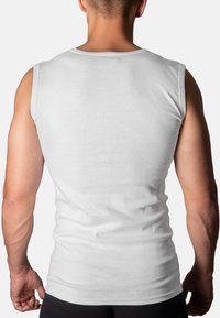 White sleeveless tank top made of a soft, lightweight fabric. Features a round neckline and fitted design, showcasing the back and shoulders.