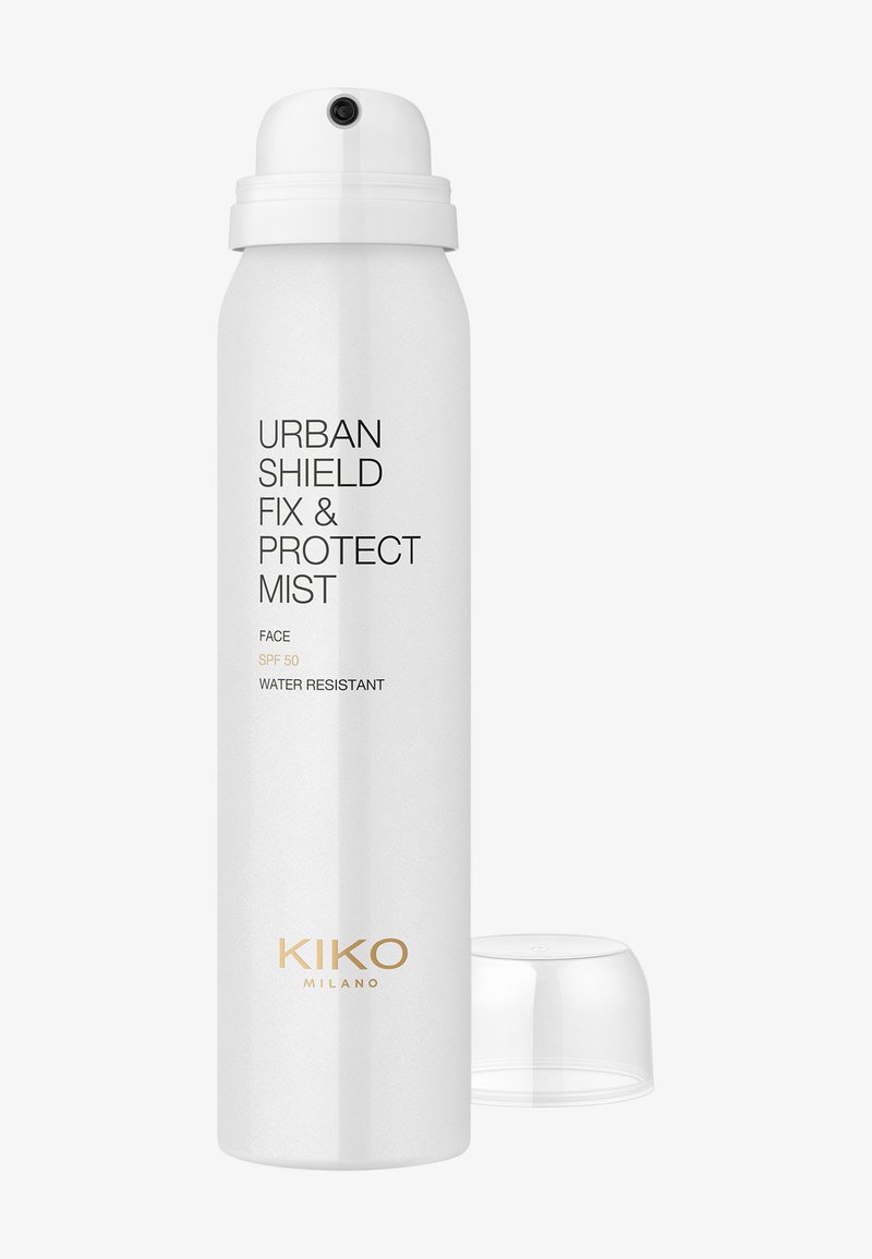 Hvit sprayflaske merket Urban Shield Fix & Protect Mist med SPF 50, vannavstøtende, og klar plastlokk ved siden av.