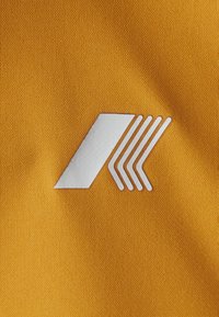 Gullduk med fin tekstur som viser en hvit logo. Logoen består av et diagonalt striper og fem parallelle linjer i økende lengde.