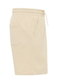 Beige cotton shorts featuring an elastic waistband, drawstring, and side pocket. Smooth texture with a relaxed fit and simple design.