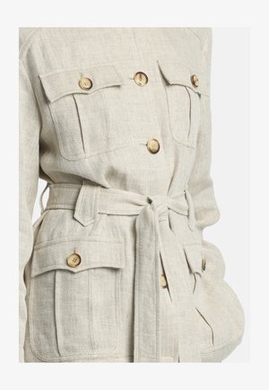 Jachetă bej cu model herringbone, cu patru buzunare cu clapetă și nasturi și o curea din același material legată în jurul taliei.