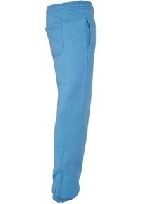 Blauwe sweatpants van zacht materiaal, met een taps toelopend ontwerp, zijzakken en ritsen bij de enkels voor extra gemak.