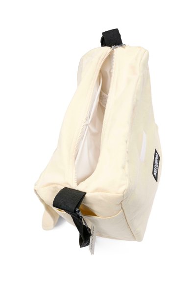 Beige stoffen tas met een ritssluiting, voorzien van een zwart handvat en merketiket. Binnenkant is gevoerd met een lichte kleur.