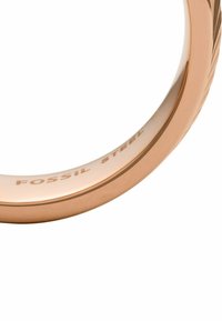 Roségoldenes Stahlring mit glatter Oberfläche, graviert mit "FOSSIL STEEL" und markanten strukturierten Akzenten entlang des Rings.