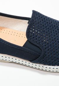 Marineblauwe instap schoenen met een mesh bovenkant, elastische zijpanelen en een textuur van espadrille-stijl zool. Beige gewatteerde binnenzool met perforaties.
