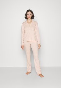 Baumwoll-Pyjama-Set in hellem Pink mit weißen Streifen; langärmlige, knöpfbare Bluse und passende Hose; weicher Stoff, entspannte Passform.