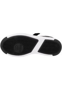 Schwarz-weißer Außensohle eines Sportschuhs mit strukturiertem Gummi für Grip, ausgestattet mit einem kreisförmigen Logo in der Mitte und einer kontrastierenden weißen Zwischensohle.