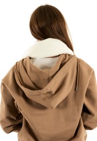 Sudadera con capucha marrón y cuello de forro polar blanco. Cuenta con un detalle de cordón y un ajuste relajado, mostrando un tejido texturizado en la vista trasera.
