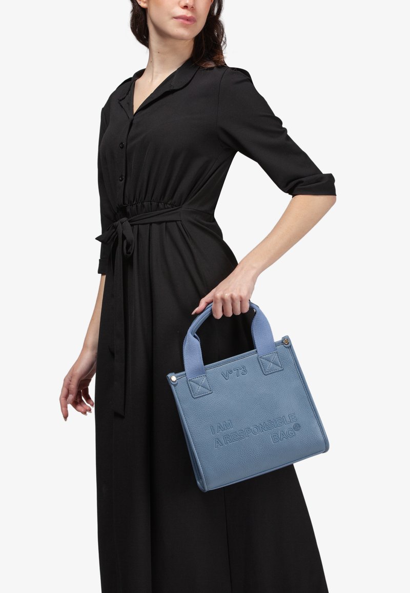 Borsa blu con texture e testo in rilievo "I AM A RESPONSIBLE BAG," con manici corti e dettagli in azzurro chiaro a contrasto.