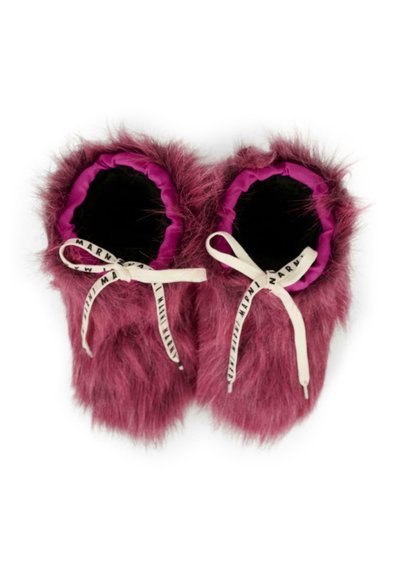 Pantofole rosa fuzzy con fodera interna nera, polsini elasticizzati e nastri bianchi con testo nero. Texture morbida, forma rotonda e design giocoso.