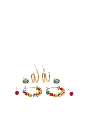 Trzy pary kolczyków: małe czerwone sztyfty, złote koła z wielokolorowymi koralikami oraz złote owalne sztyfty z niebieskimi kamieniami na białym tle.