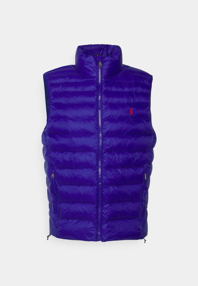 Fialová péřová vesta s vysokým límcem, horizontálním prošíváním, předním zipem a malou logem na levé hrudi. Vesta má nastavitelný lem.