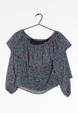 Kwiatowa bluzka z krótkimi rękawami, z czarnym tłem i małymi różowymi oraz niebieskimi kwiatami, wykonana z lekkiego materiału o luźnym kroju.