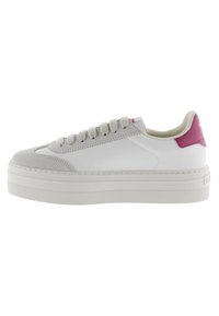 Sneaker bianco con accentatura rosa sul tallone, punta in suede, design con lacci e suola piattaforma spessa. Parte superiore in pelle liscia con dettagli testurizzati.