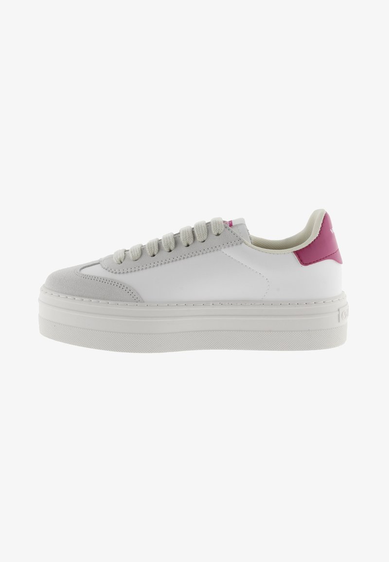 Sneaker bianco con accentatura rosa sul tallone, punta in suede, design con lacci e suola piattaforma spessa. Parte superiore in pelle liscia con dettagli testurizzati.
