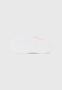 Suola di sneaker rosa con una base in gomma bianca testurizzata, caratterizzata da un motivo geometrico per una migliore aderenza e una parte superiore rosa liscia con accenti sottili.